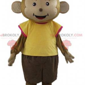 Macaco mascote marrom vestido com uma roupa colorida -