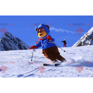 Brown and yellow bear mascot in ski outfit. Winter teddy bear -