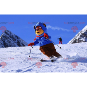 Braunes und gelbes Bärenmaskottchen im Ski-Outfit. Winter