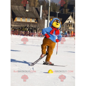 Braunes und gelbes Bärenmaskottchen im Ski-Outfit. Winter