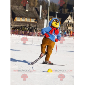 Mascota oso marrón y amarillo en traje de esquí. Oso de peluche