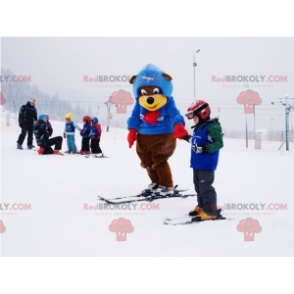 Brown and yellow bear mascot in ski outfit. Winter teddy bear -