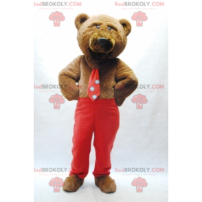 Maskot medvěd hnědý s kravatou a červené kalhoty -