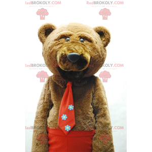 Braunbärenmaskottchen mit Krawatte und roter Hose -