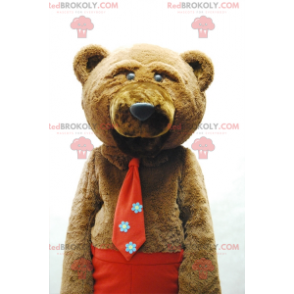 Mascotte d'ours brun avec une cravate et un pantalon rouge -