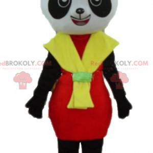 Mascota panda blanco y negro con un vestido rojo y amarillo -