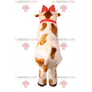 Ko maskot med röd rosett och klocka - Redbrokoly.com