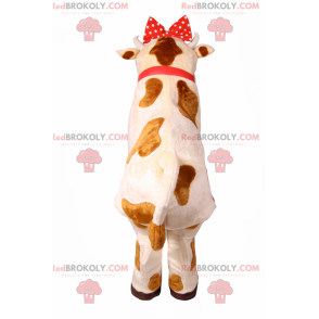Ko maskot med röd rosett och klocka - Redbrokoly.com