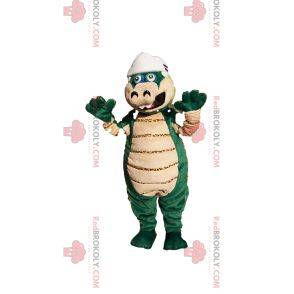Grünes und beiges Dinosauriermaskottchen mit einem Baseballhelm