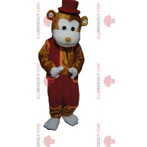 Glad brun apa maskot med en vinröd outfit och hatt