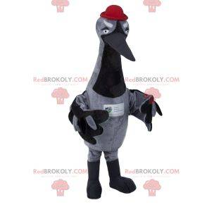Mascotte de cigogne grise avec un chapeau rouge