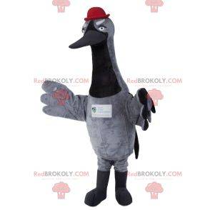 Mascotte de cigogne grise avec un chapeau rouge