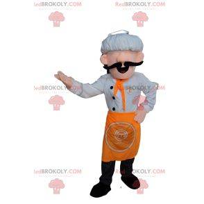 Maskotka szefa kuchni w białym kapeluszu i pomarańczowym fartuchu.