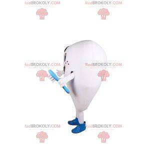 Mascote de dente branco sorridente e escova de dente azul