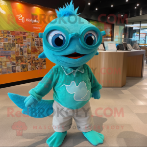 Turquoise Goldfish mascot costume character dressed with a Graphic Tee and Eyeglasses