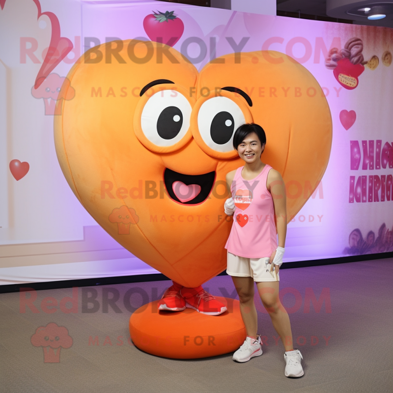 Peach Heart mascot costume character dressed with a Tank Top and Shoe clips Peach Heart mascot costume character dressed with a Tank Top and Shoe clips