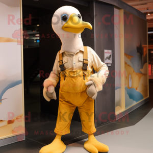 Gold Albatross mascot costume character dressed with a Overalls and Keychains