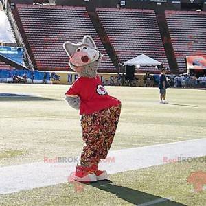 Mascota lobo gris con pantalones florales y una camiseta roja -