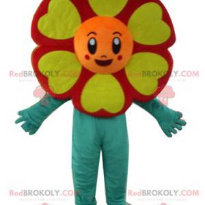 Very smiling red orange yellow and green flower mascot -