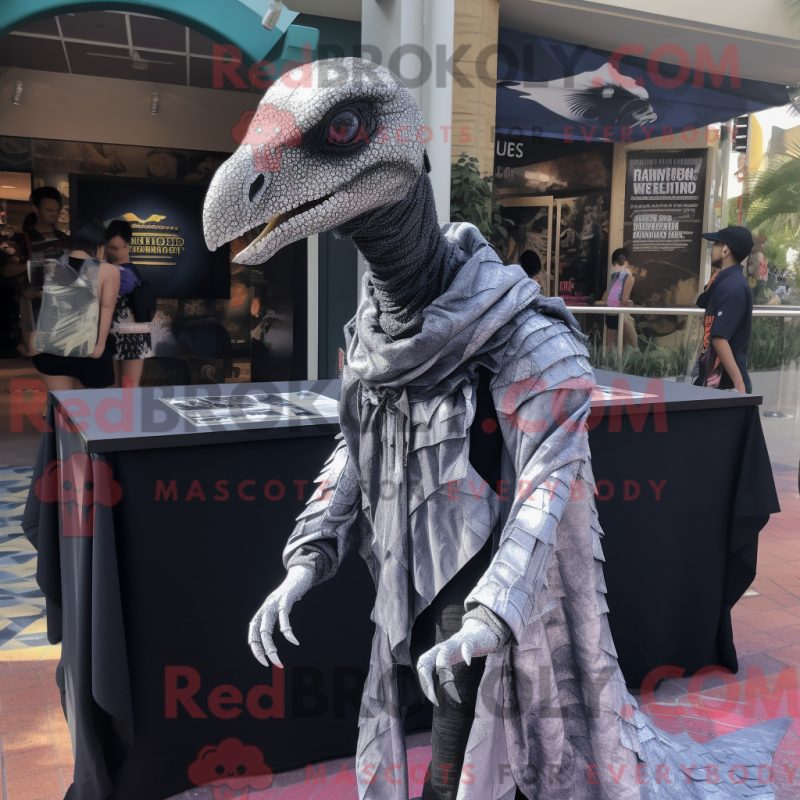 Mascot character of a Silver Velociraptor dressed with a Graphic Tee and Shawls Mascot character of a Silver Velociraptor dressed with a Graphic Tee and Shawls