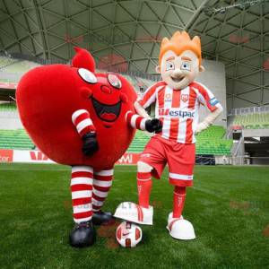 2 mascotes, um coração vermelho gigante e um jogador de futebol