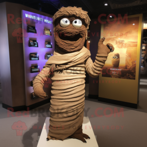 Brown Mummy mascot costume character dressed with a T-Shirt and Shawl pins
