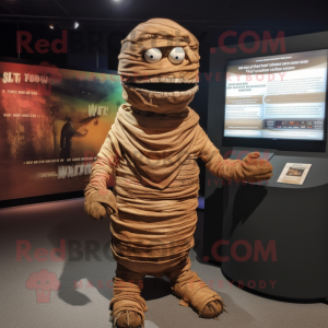 Brown Mummy mascot costume character dressed with a T-Shirt and Shawl pins