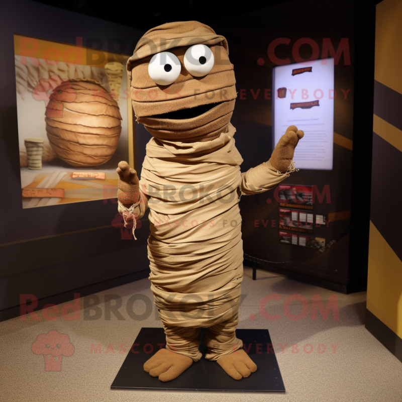 Brown Mummy mascot costume character dressed with a T-Shirt and Shawl pins