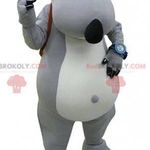 Mascote urso cinza e branco com uma mochila escolar -