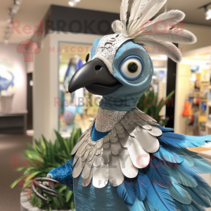 Silver Peacock mascot costume character dressed with a Chambray Shirt and Rings