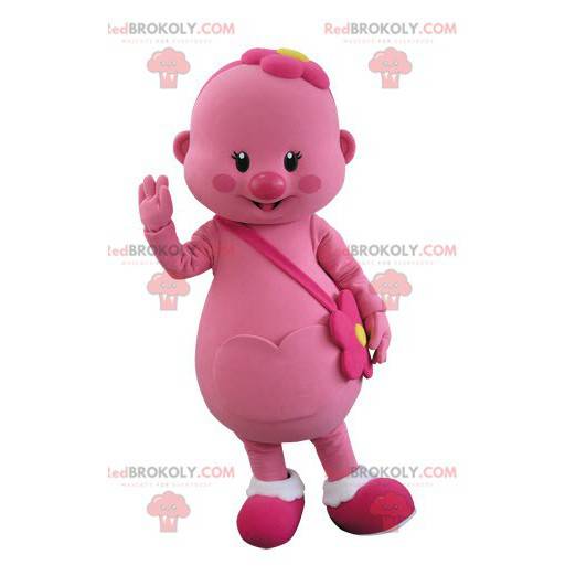 Mascotte de bonhomme rose avec une fleur sur la tête -