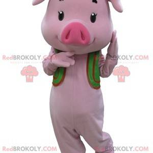 Rosa Schweinemaskottchen mit einer grünen Weste - Redbrokoly.com