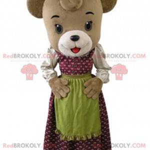 Brun björnmaskot klädd i en klänning med ett förkläde -