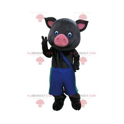 Mascotte di maiale nero e rosa con pantaloni blu -