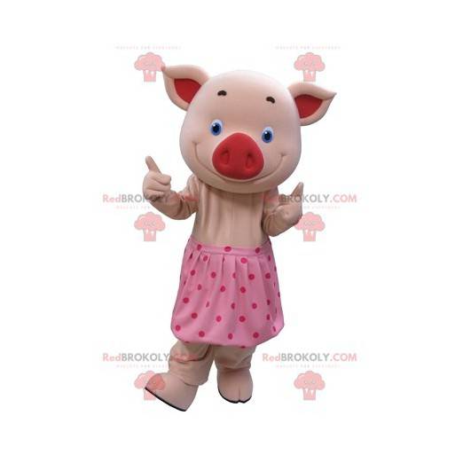 Różowa maskotka świnia z niebieskimi oczami i spódnicą w kropki