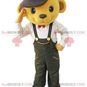 Žlutý medvěd maskot oblečený v montérkách s baret -