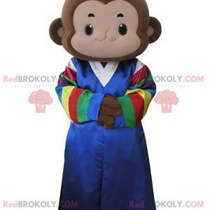 Mascotte de singe marron habillé d'une robe multicolore -