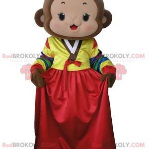 Brun abe maskot med en farverig kjole - Redbrokoly.com