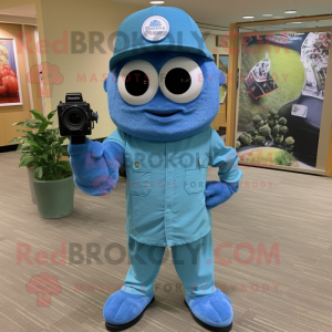Blue Camera mascot costume character dressed with a Cargo Shorts and Hat pins