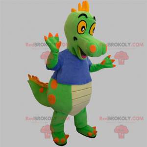 Mascota dinosaurio verde y naranja con una camiseta azul -