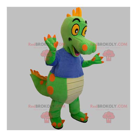 Mascote de dinossauro verde e laranja com uma camiseta azul -