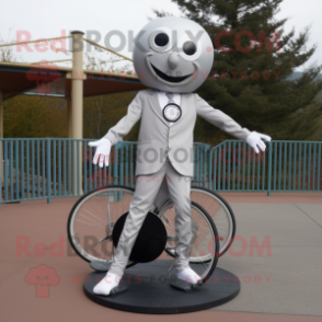 Silver Unicyclist mascot costume character dressed with a Suit Jacket and Shoe clips