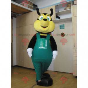 Mascotte d'abeille noire et jaune avec une salopette verte -