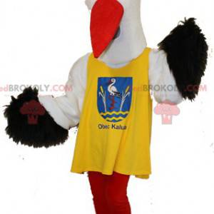 Mascotte de cigogne noire et blanche avec un dossard jaune -