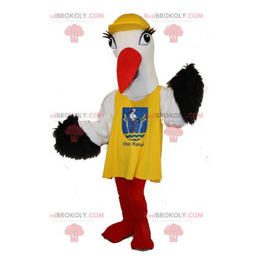 Sort og hvid stork maskot med en gul hagesmæk - Redbrokoly.com