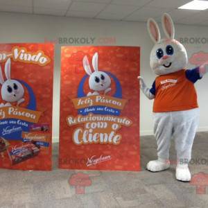 Mascota de conejo blanco regordeta y linda vestida de naranja -