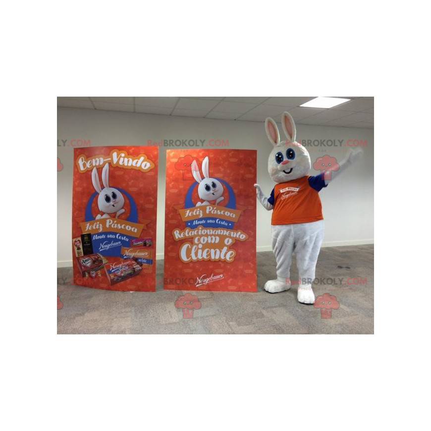 Fyllig och gullig vit kaninmaskot klädd i orange -
