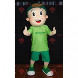 De jonge mascotte van de tienerjongen in het groen gekleed -