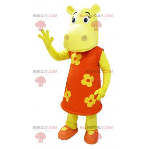 Geel nijlpaard mascotte gekleed in een oranje bloemenjurk -