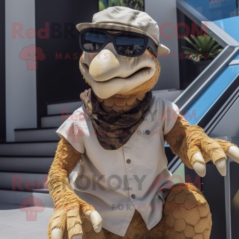Tan Utahraptor mascot costume character dressed with a Trousers and Sunglasses Tan Utahraptor mascot costume character dressed with a Trousers and Sunglasses